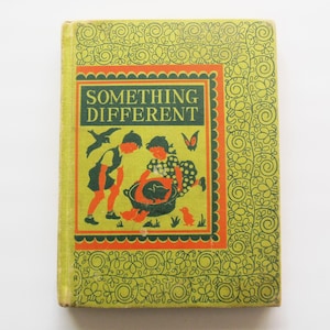 May include: A vintage book titled "Something Different" with a green cover and a central illustration. The illustration depicts two children interacting with a cat and a duck. The cover has a decorative border in orange and green.