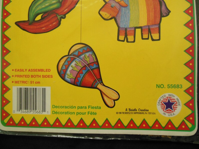 May include: A set of five colorful paper decorations for a fiesta. The decorations include a red chili pepper, a maraca, a donkey pi&ntilde;ata, and two green peppers. The decorations are printed on both sides and are easily assembled. The package includes the text "Decoraci&oacute;n para Fiesta" and "D&eacute;coration pour F&ecirc;te".