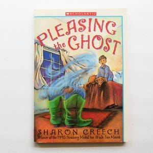 May include: A paperback book titled Pleasing the Ghost by Sharon Creech with a Scholastic logo. The cover illustration depicts a child and a dog sitting on a bed, with a pair of bright green boots and swirling blue mist in the foreground.