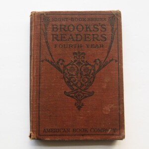 May include: A vintage red book with the title "Brooks's Readers Fourth Year" and the publisher "American Book Company".