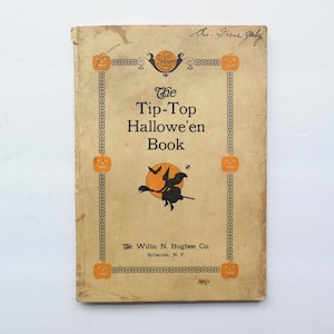 May include: The cover of a vintage book titled "The Tip-Top Hallowe'en Book" with an illustration of a witch flying on a broomstick. The book is published by The Willis N. Bugbee Co. in Syracuse, N.Y.