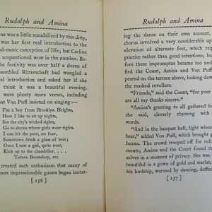 May include: A black and white book with the title "Rudolph and Amina" on the cover. The book is open to a page with text about a character named Amina and a song she sings. The page numbers are 156 and 157.
