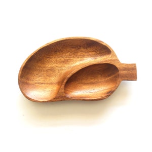 May include: A wooden serving tray with two separate compartments. The tray is brown and has a natural wood finish.