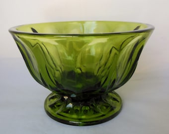 May include: A green glass bowl with a fluted design and a pedestal base.