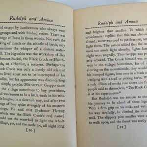 May include: Two pages from a vintage book titled "Rudolph and Amina". The pages are yellowed with age and the text is printed in black ink. The text describes a mysterious character known as the Black Crook, who is an alchemist and sorcerer. The text also mentions a waterfall that can be used to light the whole village.