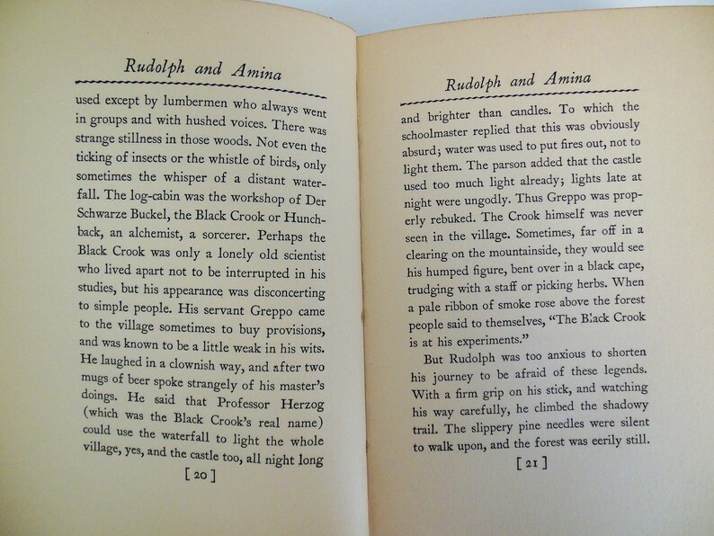 May include: Two pages from a vintage book titled "Rudolph and Amina". The pages are yellowed with age and the text is printed in black ink. The text describes a mysterious character known as the Black Crook, who is an alchemist and sorcerer. The text also mentions a waterfall that can be used to light the whole village.