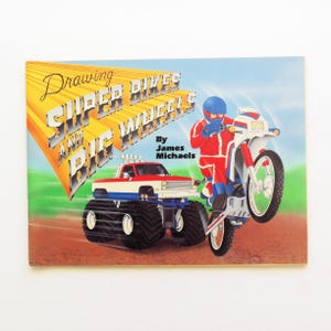 May include: A book cover with a yellow, orange, and red title "Drawing Super Bikes and Big Wheels" by James Michaels. The cover features a cartoon illustration of a monster truck and a dirt bike.