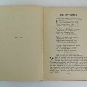 May include: An open book with a cream-colored cover and pages. The book is titled "Merry Times" and features a poem about the birth of Jesus Christ. The text is in black ink and the pages are slightly yellowed with age.