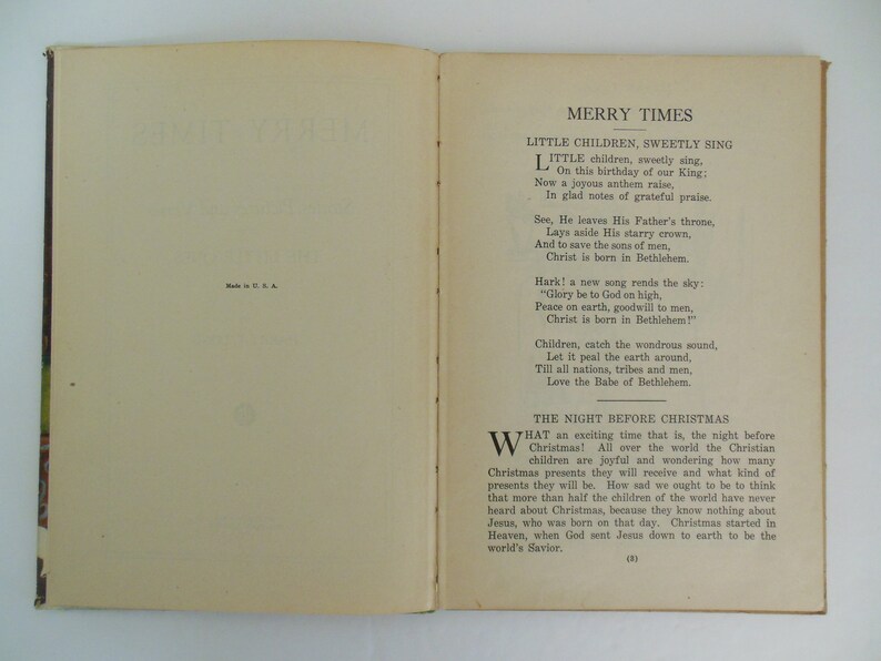 May include: An open book with a cream-colored cover and pages. The book is titled "Merry Times" and features a poem about the birth of Jesus Christ. The text is in black ink and the pages are slightly yellowed with age.