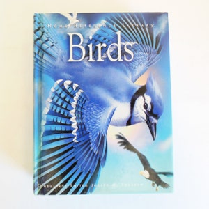 May include: A blue and white book with the title "Birds" on the cover. The cover features a blue jay with its wings spread and a bald eagle flying in the background. The book is part of the "Home Reference Library" series.