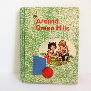 May include: A vintage children's book titled "Around Green Hills" with a green cover and a picture of two children and a rabbit on the front.