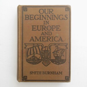 May include: A brown book with the title "Our Beginnings in Europe and America" by Smith Burnham. The cover features a decorative design with ships and a crest.