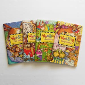 May include: A set of four colorful Wee Sing children's books with illustrated covers. The titles are Wee Sing For Baby, Wee Sing Bible, Wee Sing And Play, and Wee Sing Sing-Alongs.