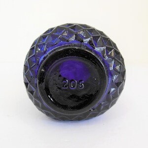 May include: Cobalt blue glass bottle with a diamond pattern and the number 205 on the bottom.