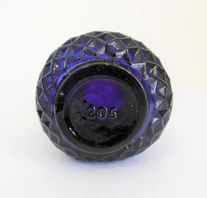 May include: Cobalt blue glass bottle with a diamond pattern and the number 205 on the bottom.