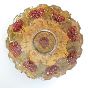 May include: A vintage glass serving dish with a scalloped edge. The dish is decorated with a floral pattern in shades of brown, red, and green.
