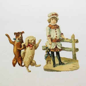 May include: A vintage paper doll set featuring a girl in a white dress with a brown belt, holding a doll. The girl is standing by a wooden fence. Two dogs, one brown and one white, are dancing in the foreground.