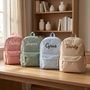 Könnte beinhalten: Ein Set aus drei Keramikbechern mit gesprenkelter, matter Oberfläche. Jeder Becher hat eine andere Farbe: hellblau, creme und grau. Die Becher haben ein schlichtes, modernes Design und einen bequemen Griff.