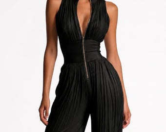 May include: A black sleeveless jumpsuit featuring a deep V-neckline with a central zipper closure, a fitted waist panel, and wide-leg trousers. The bodice and the full-length pant legs are constructed with fine vertical pleats throughout the fabric.