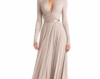 May include: A floor-length, long-sleeved dress in a solid light beige color. The garment features a deep V-neckline with gathered fabric at the waist, creating a draped effect. A thin, metallic gold-toned belt is cinched around the waistline.
