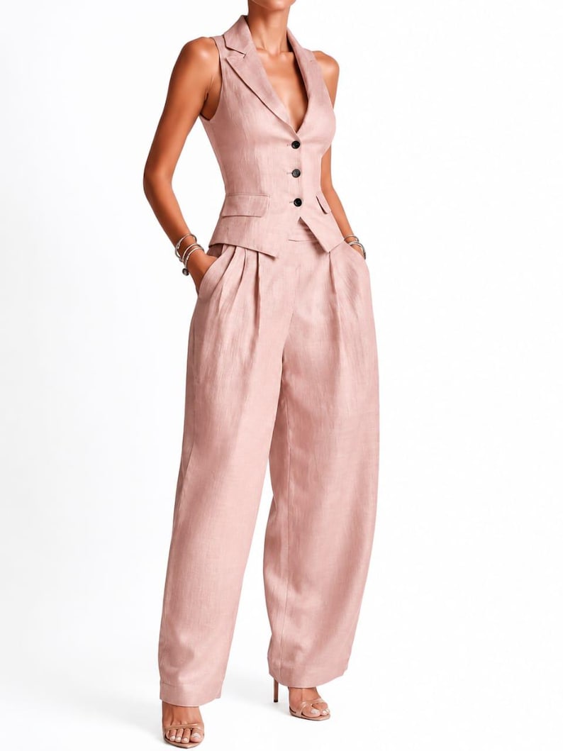 May include: A dusty rose sleeveless vest and matching wide-leg trousers set. The vest features a notched lapel, a deep V-neckline, and three dark buttons down the front. The trousers have a high-waisted fit with pleats and side pockets.