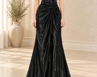 May include: A floor-length black gown with an off-the-shoulder neckline and short ruffled sleeves. The bodice features a structured corset-style design, while the skirt includes a central gathered knot detail that creates vertical folds in the fabric.