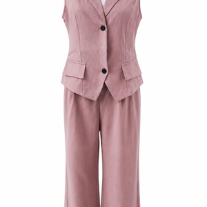 May include: A dusty rose sleeveless vest and matching wide-leg trousers set. The vest features a notched lapel, two black buttons, and two small flap pockets at the waist. The trousers have a clean, straight-leg cut with a high-waisted design.