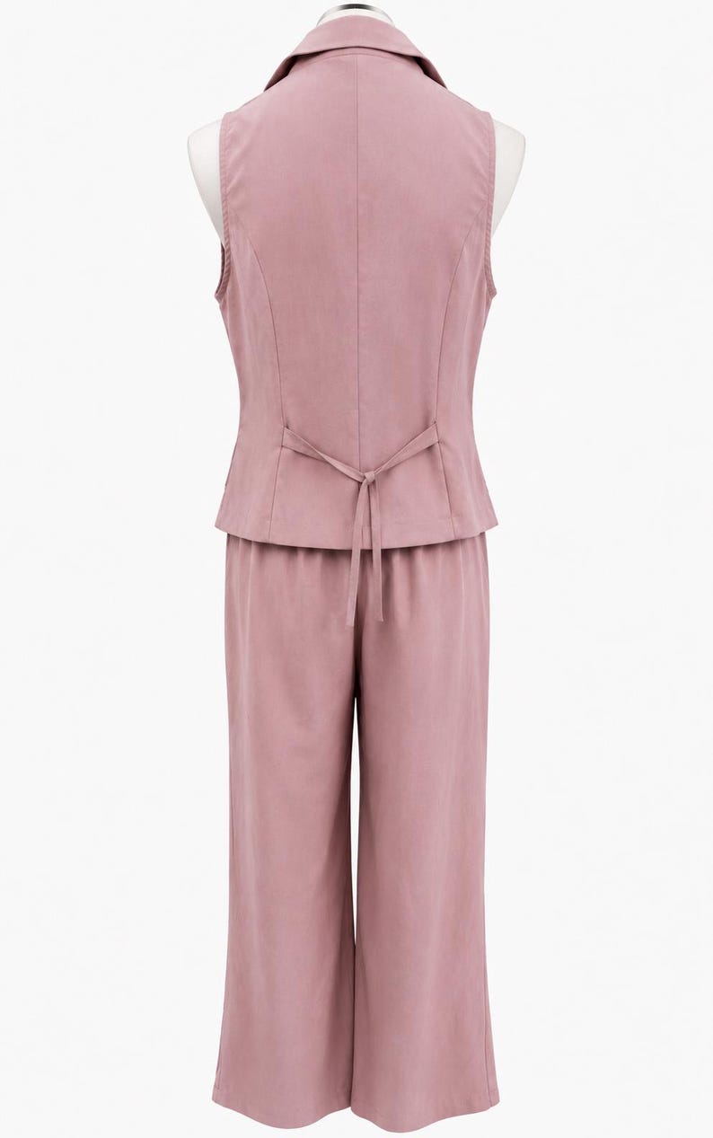 May include: A dusty rose two-piece set consisting of a sleeveless vest and wide-leg trousers. The vest features a notched collar and a thin tie-back detail at the waist. The trousers have a straight-cut silhouette and a clean, solid-colored finish.