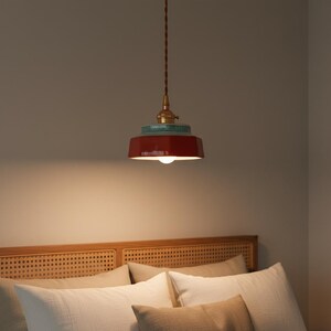 Lámpara colgante de cerámica en rojo vibrante con portalámparas de cobre para interiores modernos.