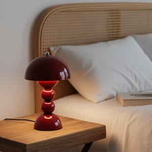 Lámpara de mesa roja contemporánea con acabado metálico brillante para decoración moderna del hogar.