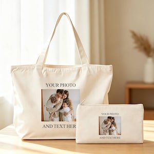 Peut inclure: Un sac fourre-tout et une pochette zippée assortis, de couleur crème. Les deux articles présentent un cadre photo rectangulaire avec le texte "YOUR PHOTO" au-dessus et "AND TEXT HERE" en dessous. Le sac fourre-tout a deux poignées.