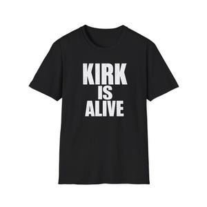 May include: Black crew neck t-shirt with the white text "KIRK IS ALIVE" in a bold, sans-serif font. The shirt is a solid black color, and the text is centered on the chest.