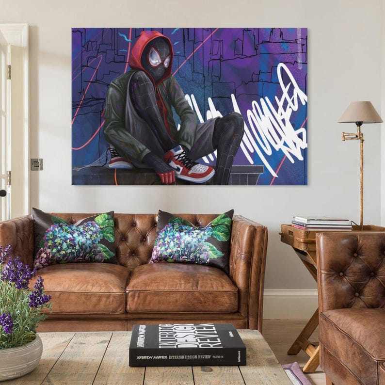 May include: A large canvas art print featuring a superhero in a black and red suit, seated with a cityscape backdrop. The artwork has a graffiti-style aesthetic with vibrant colors and bold lines. The superhero is wearing red and white sneakers.