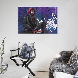 May include: A canvas print featuring a superhero in a red hooded jacket, black pants, and red and white sneakers. The character is seated against a graffiti-covered wall with purple and blue hues. The artwork has a modern, urban aesthetic.