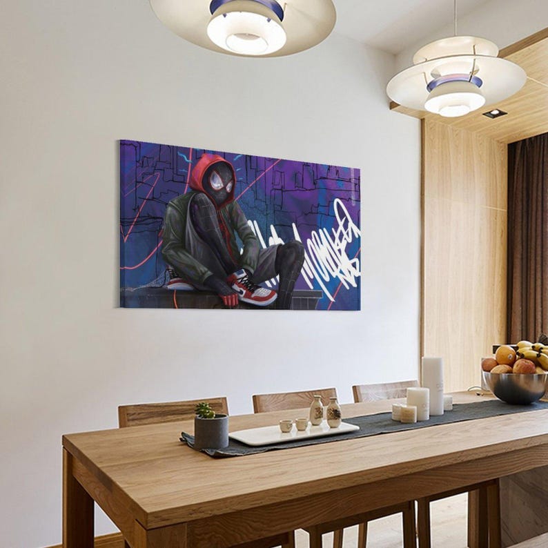 May include: A canvas print featuring a stylized illustration of a superhero in a red hoodie and black mask, seated against a graffiti-covered background. The artwork showcases a vibrant color palette with shades of purple, blue, and red, and is displayed in a dining room.