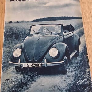 May include: A vintage magazine cover showing a dark blue convertible car on a dirt track. The title "ENERGIE" is at the top, with text indicating it's a technical journal from Berlin, dated March 1939. The car has a license plate.