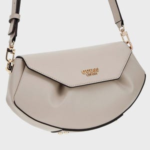 May include: A light gray Guess crossbody bag with a flap closure. The bag has a gold-colored chain and the Guess logo in gold. The bag has a long, adjustable strap and a black trim.