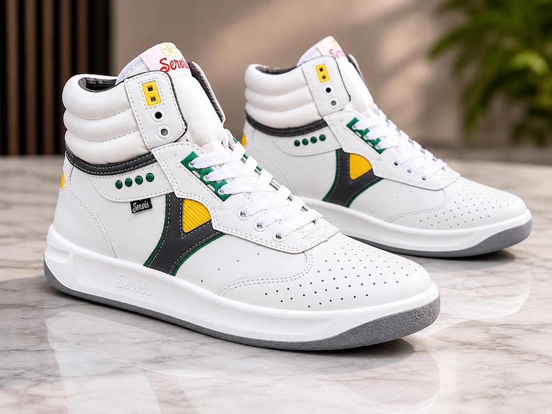 Puede incluir: Par de zapatillas altas blancas con suelas grises. Los detalles incluyen amarillo, verde y gris oscuro. Las zapatillas tienen la palabra "Servis" en el lateral y la leng&uuml;eta.