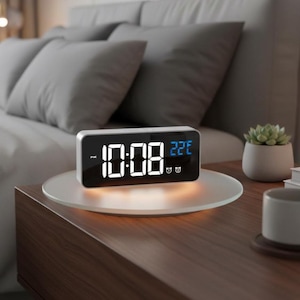May include: A digital alarm clock displaying 10:08 PM and 22°C. The clock has a white frame and a black screen with white and blue digits. It sits on a round, illuminated glass surface on a wooden nightstand.