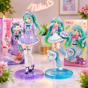 Könnte beinhalten: Zwei Hatsune Miku Anime-Figuren auf runden Sockeln. Die linke Figur trägt ein violettes Dienstmädchen-Outfit mit Katzenohren und hält einen kleinen Kuchen. Die rechte Figur trägt ein blau-weißes Outfit mit Katzenohren und hält eine Farbpalette.