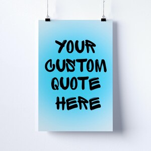 May include: A poster with a light blue gradient background. The poster has the words "YOUR CUSTOM QUOTE HERE" in large, black, handwritten-style font. The poster is held by two black clips.