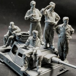 Op de afbeelding: Een grijs model van een tank met vijf miniatuurfiguren. De figuren, gekleed in werkkleding, stellen soldaten of bemanningsleden voor. De tank heeft een lange loop en gedetailleerde kenmerken.