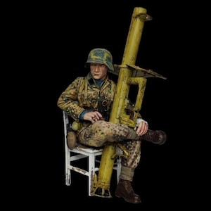 Puede incluir: Una taza de cerámica blanca con un asa negra y el texto "But First, Coffee" en negrita negra. La taza está sobre un fondo borroso. La taza mide aproximadamente 10 cm de altura.