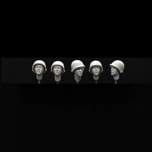 Może przedstawiać: Pięć szczegółowych miniaturowych popiersi żołnierzy w białych hełmach. Każde popiersie jest zamontowane na cienkim, złocistym pręcie. Głowy wyrażają różne emocje na czarnym tle.