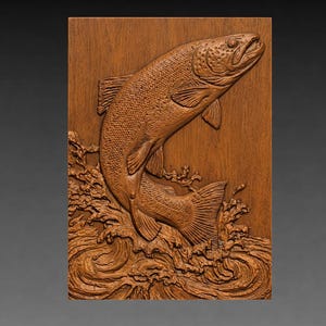 May include: A wooden relief carving of a fish leaping out of water. The fish is detailed with scales and fins, and the water is depicted with swirling waves. The carving is made of a warm, brown wood and is mounted on a rectangular panel.