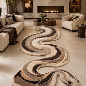 Könnte beinhalten: Ein großer, länglicher Teppich in Schlangenform mit einem geschichteten, wellenförmigen Muster in den Farben Creme, Beige, Taupe und Dunkelbraun. Der Teppich hat einen ausgeprägten Kopf mit dunklen ovalen Augen und einer herausragenden schwarzen Zunge.