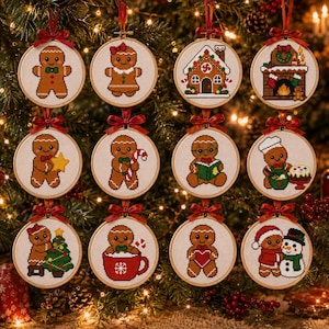 Può includere: Un set di dodici telai da ricamo circolari in legno contenenti disegni a punto croce di personaggi di pan di zenzero, una casetta di pan di zenzero e un camino, ciascuno sormontato da un fiocco rosso per l'albero di Natale.