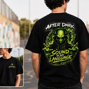Könnte beinhalten: Ein schwarzes T-Shirt mit einem Grafikdruck eines grünen Außerirdischen, der Kopfhörer trägt. Das Rückendesign enthält den Text "AFTER DARK" und "SOUND IS MY LANGUAGE" in einer stilisierten Schrift. Eine kleinere Version ist auf der Brust.