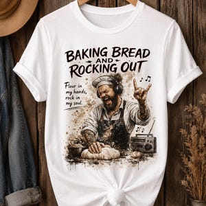 Könnte beinhalten: Ein weißes T-Shirt mit einer Grafik eines Bäckers, der Kopfhörer und eine Schürze trägt und Teig knetet. Der Text lautet: BAKING BREAD AND ROCKING OUT. Flour in my hands, rock in my soul. Das Design enthält Musiknoten und ein Radio.