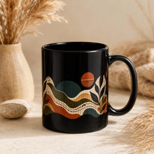 Könnte beinhalten: Ein schwarzer Keramikbecher mit einem grafischen Design aus geschichteten, wellenförmigen Bändern in Terrakotta, Olivgrün und Creme. Das Muster zeigt eine kreisförmige orangefarbene Sonne, gepunktete Linien und stilisierte Blattmotive.